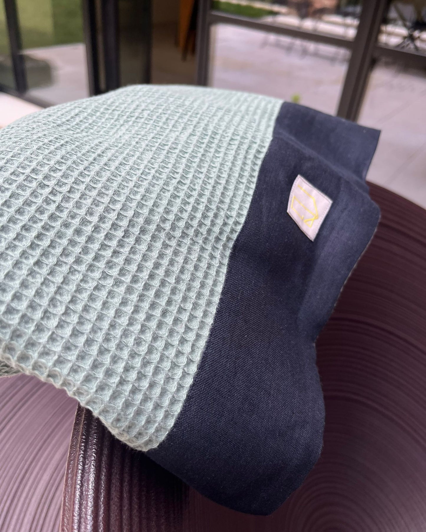 dettaglio trama a nido d'ape e bordo blu con etichetta